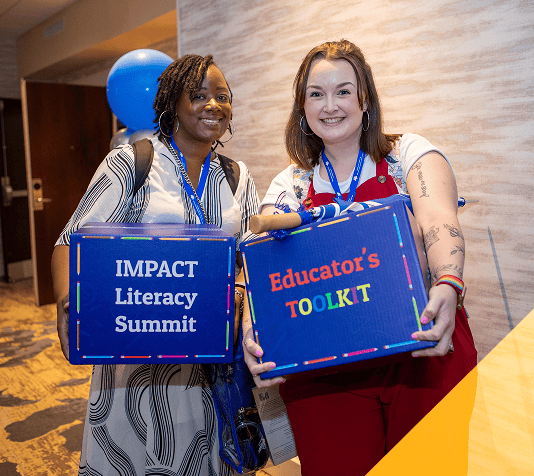 Two women holding Impact Literacy Summit and Educator's Toolkit boxes at EPI Center.