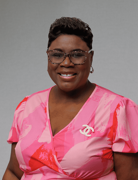 EPI Center Board of Directors member in a pink blouse with glasses and a Chanel brooch.